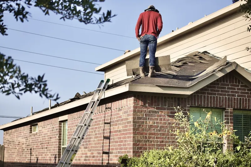 Professional roofer working on a residential roof in Sperry Springs